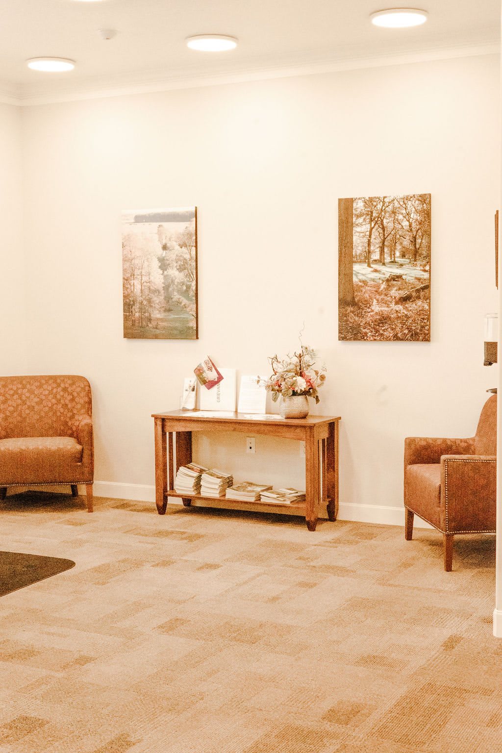 A cozy waiting room with comfortable chairs and decorative paintings.