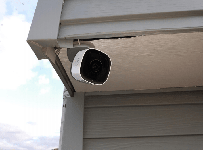 An outdoor security camera mounted on a building corner for surveillance.