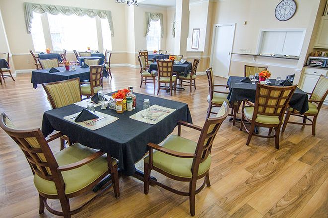A neatly arranged dining room with tables and chairs set for a meal.