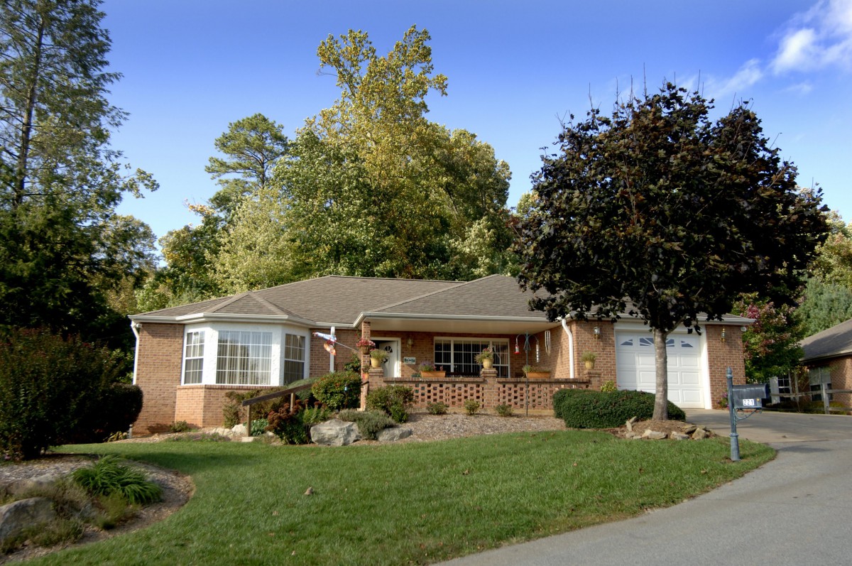 A cozy suburban house with a well-maintained yard and surrounding trees.