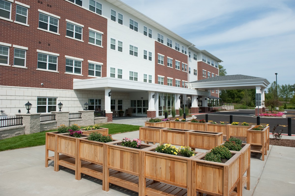 A modern building with a landscaped garden featuring wooden planters.