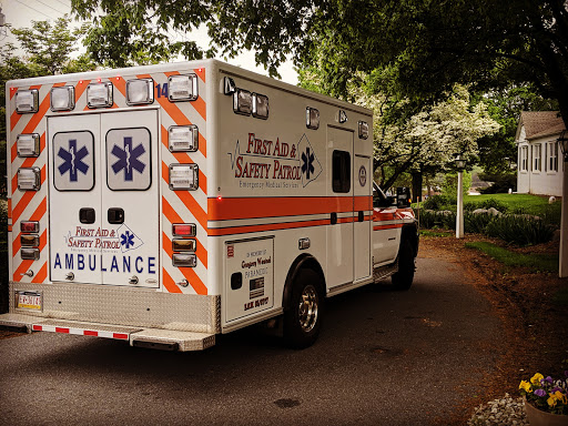 An ambulance parked on a tree-lined street, ready to assist in emergencies.