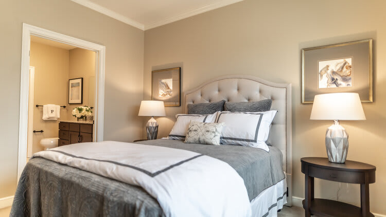 A cozy bedroom with a neatly made bed, stylish decor, and soft lighting.