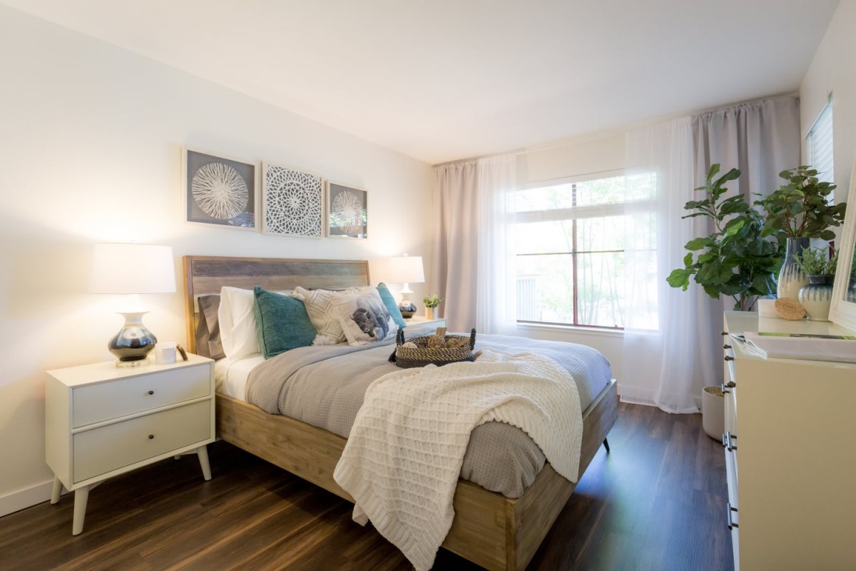 A cozy and modern bedroom featuring a stylish bed, decorative pillows, and ample natural light.
