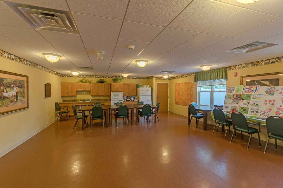 A spacious dining and kitchen area with tables and chairs arranged neatly.