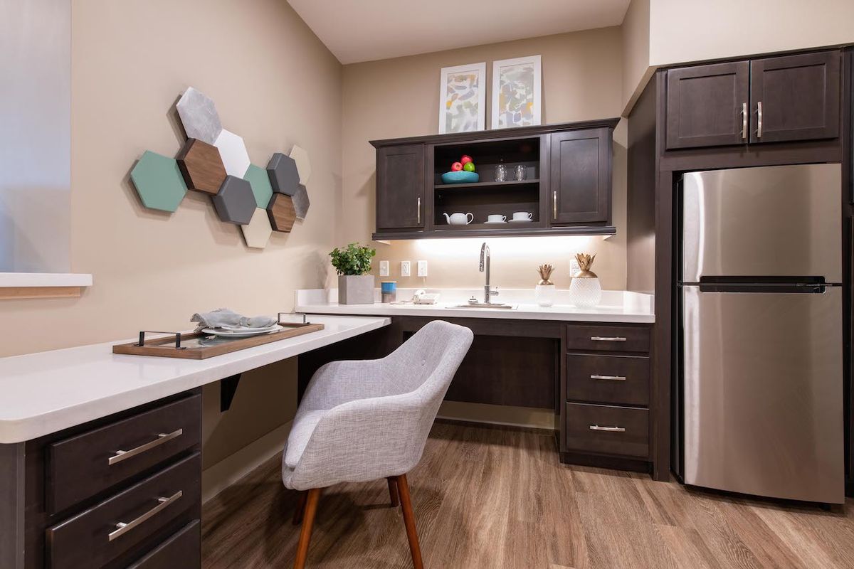 A modern home office with a comfortable chair, sleek desk, and stylish shelving.