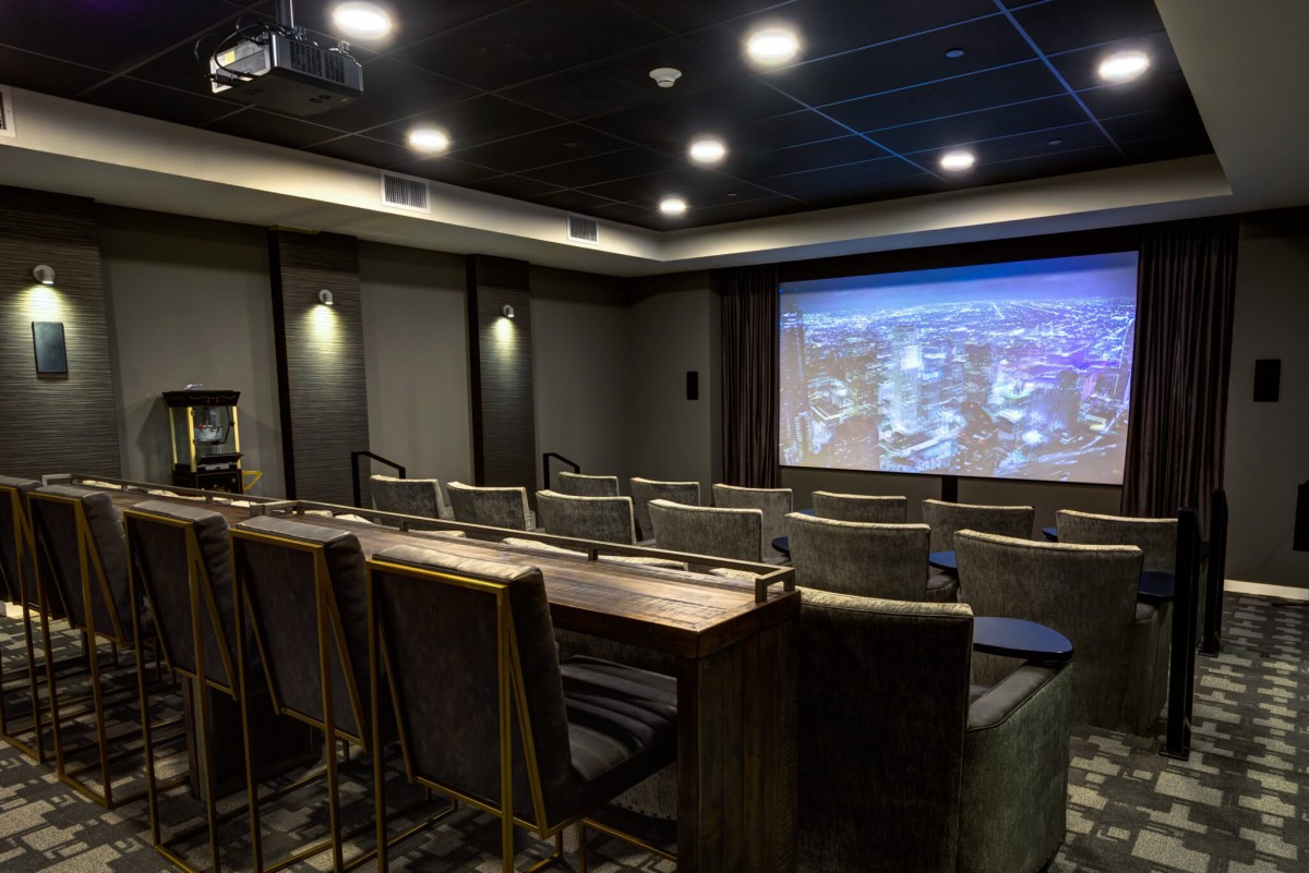 A modern home theater setup with luxury seating and a large projector screen.