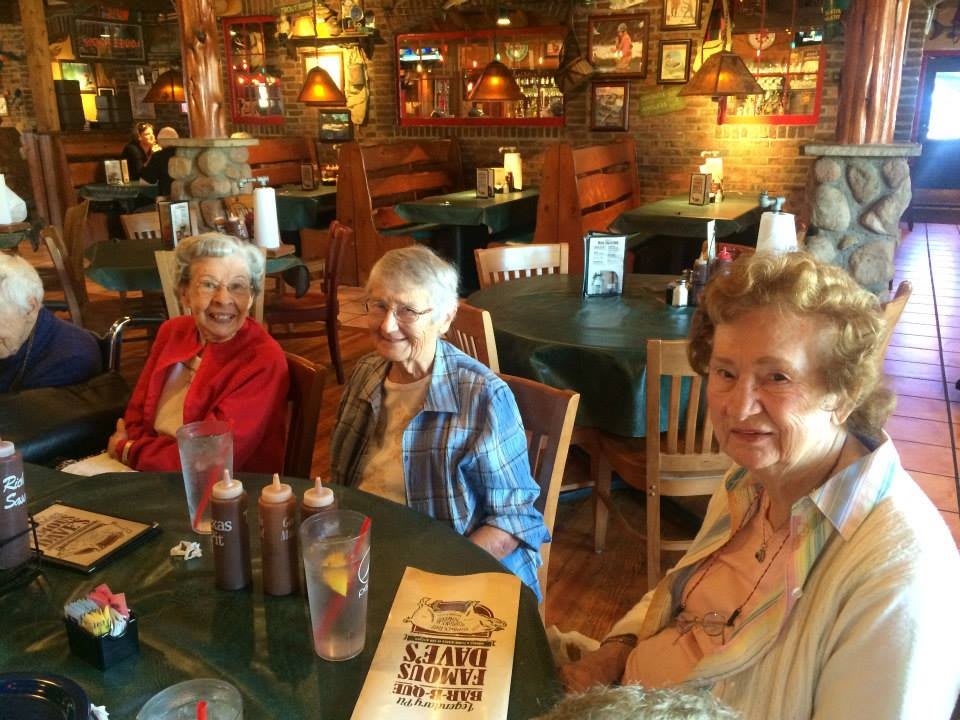 A group of senior women enjoying a meal together at a restaurant.