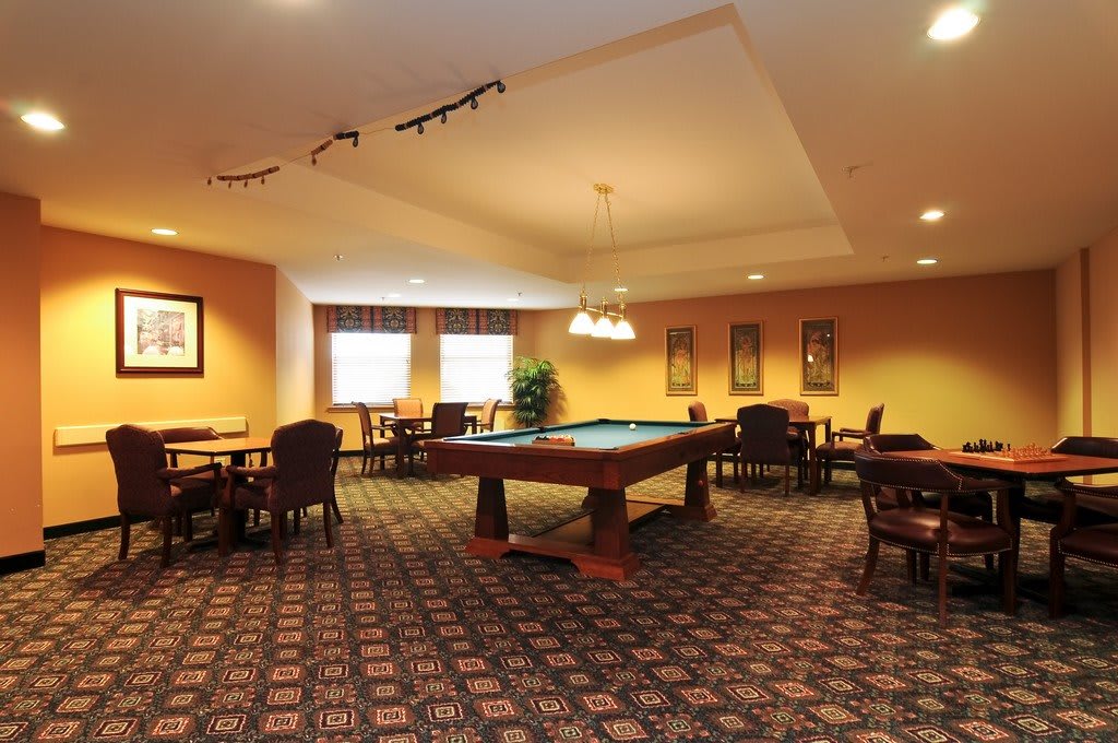 A cozy game room featuring a pool table and seating area.