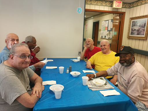 A group of elderly men enjoying a meal together in a social setting.