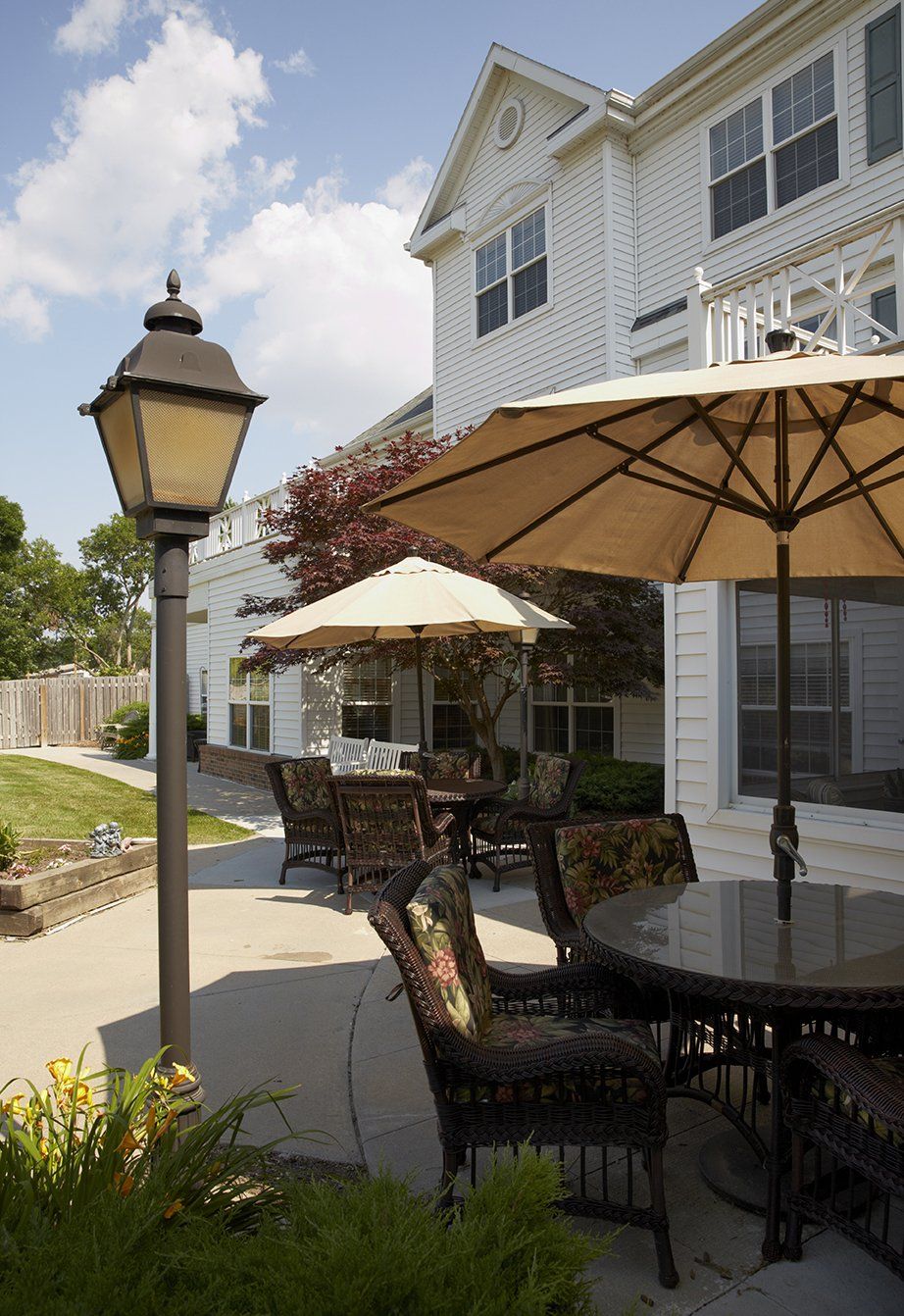 A charming outdoor patio area with tables, chairs, and umbrellas next to a building.