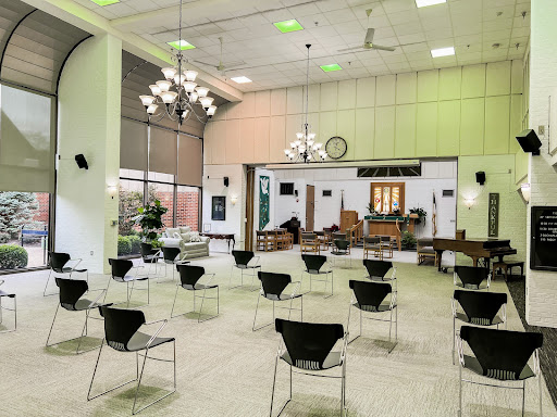 A spacious event venue set up with chairs, featuring modern lighting and decor.