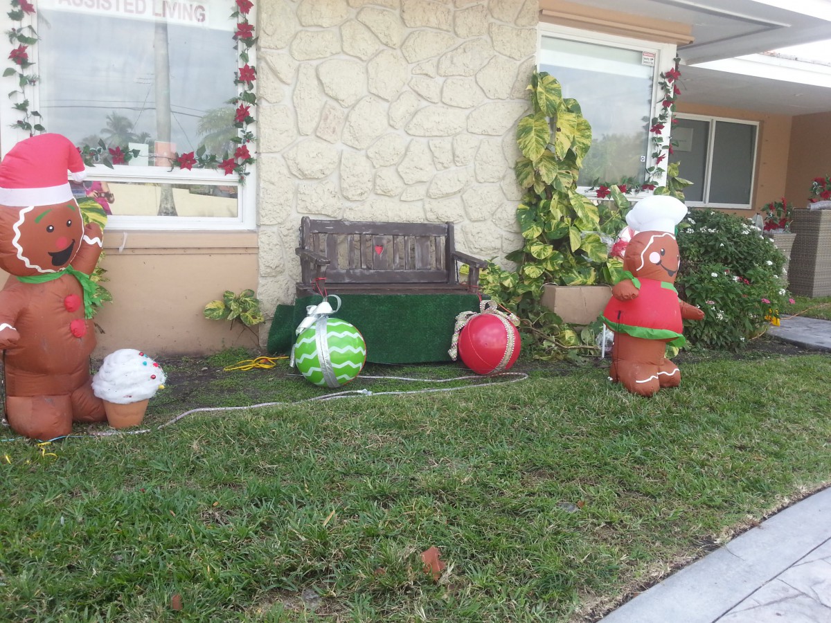 Inflatable Christmas decorations in a yard, featuring festive characters and ornaments.