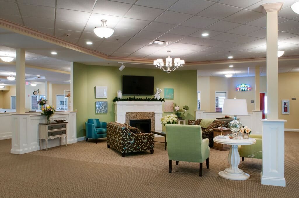 A cozy living room with modern decor featuring a fireplace, television, and comfortable seating area.