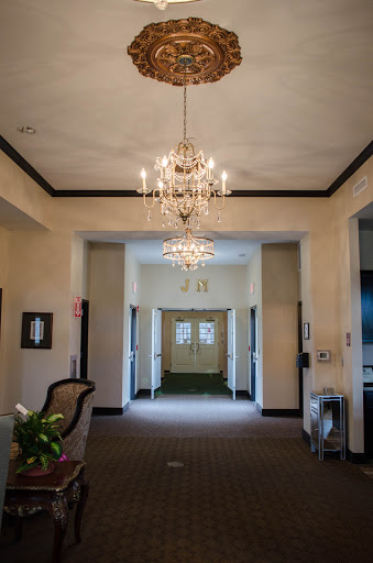 An elegant lobby featuring two chandeliers and a spacious hallway, creating an inviting atmosphere.