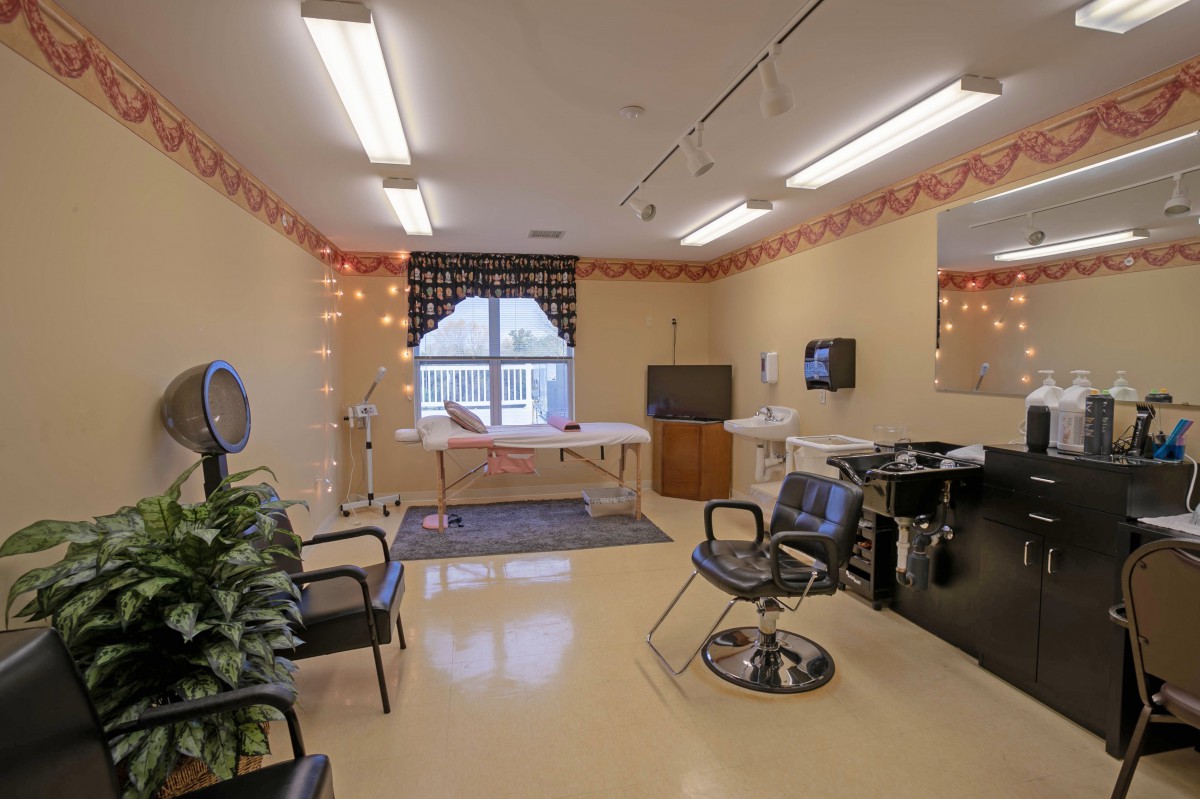 A cozy salon interior featuring chairs, mirrors, and styling equipment.