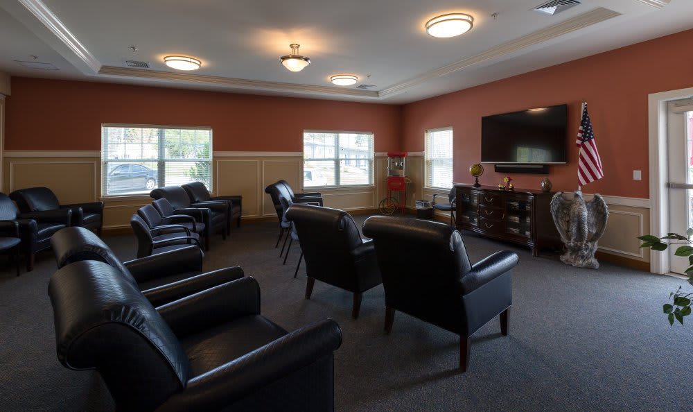 A spacious lounge with comfortable seating and a large television.