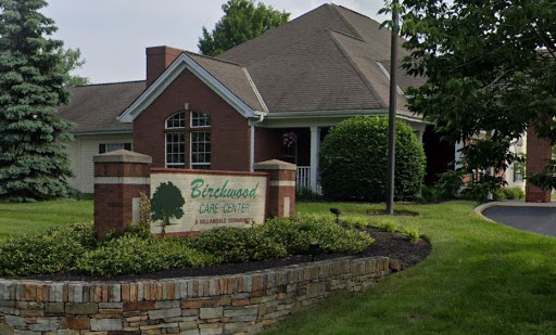 A welcoming entrance to a residential complex, featuring well-maintained landscaping.