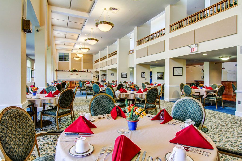 A spacious and elegantly decorated dining room with tables set for guests.