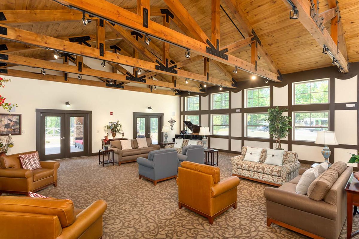 A spacious living room with modern furniture and a wooden ceiling.