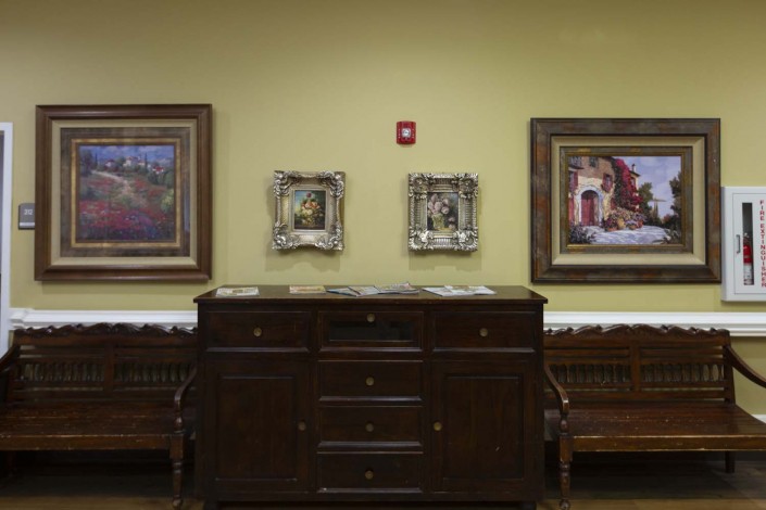 An interior view showcasing wooden furniture and framed artwork on the wall.