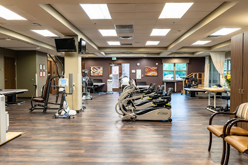 A spacious and well-lit gym featuring various exercise equipment.