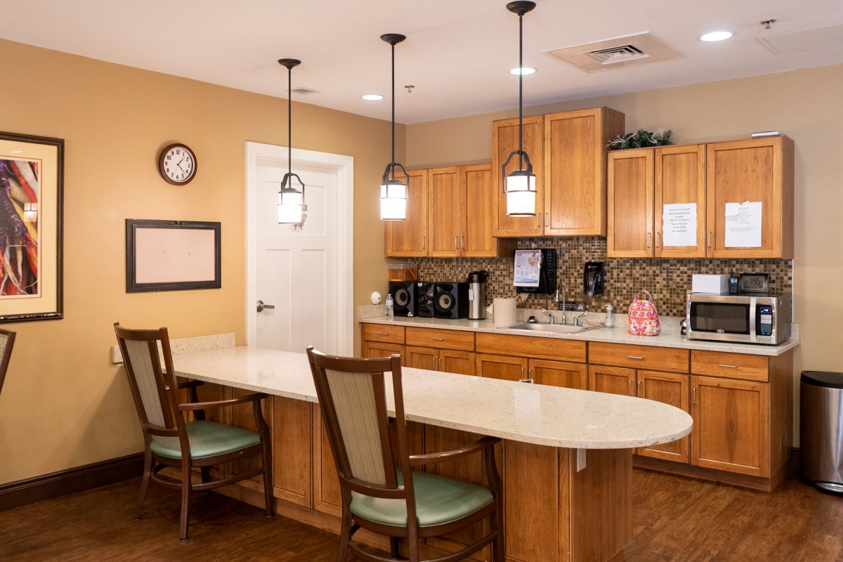 A cozy kitchen space with wooden cabinets, a long countertop, and pendant lighting.