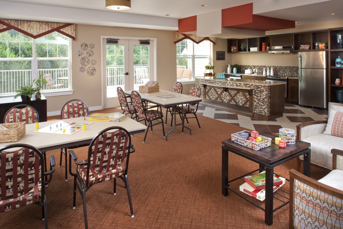 A cozy communal dining area with tables, chairs, and a small serving counter.