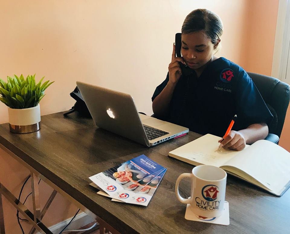 Person working at a desk with a laptop and phone.