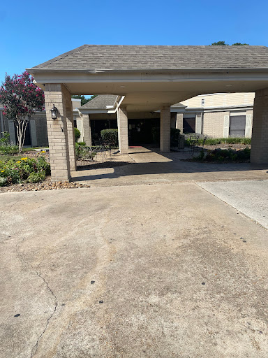 A view of a residential driveway leading to a garage with landscaped areas.