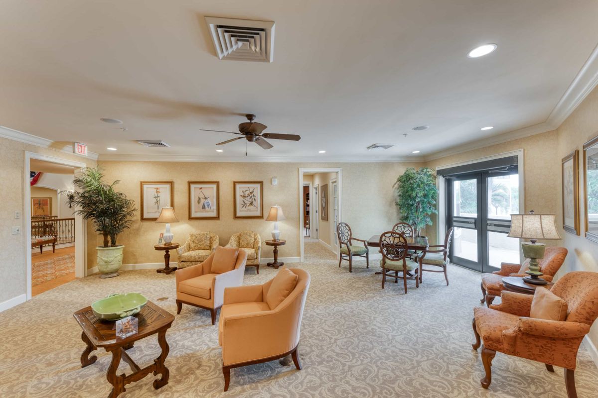 A spacious living room with comfortable seating, tables, and elegant decor.