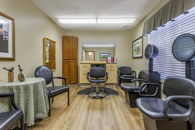 A cozy salon interior with chairs, a mirror, and a hair dryer.