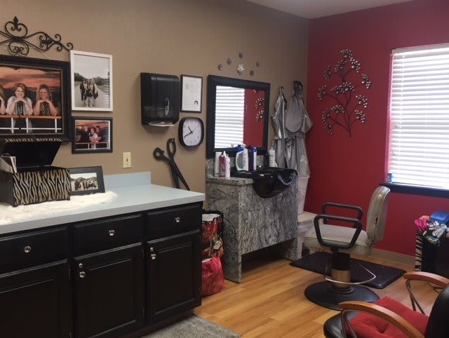 A cozy hair salon interior featuring styling chairs, beauty products, and decorative elements.