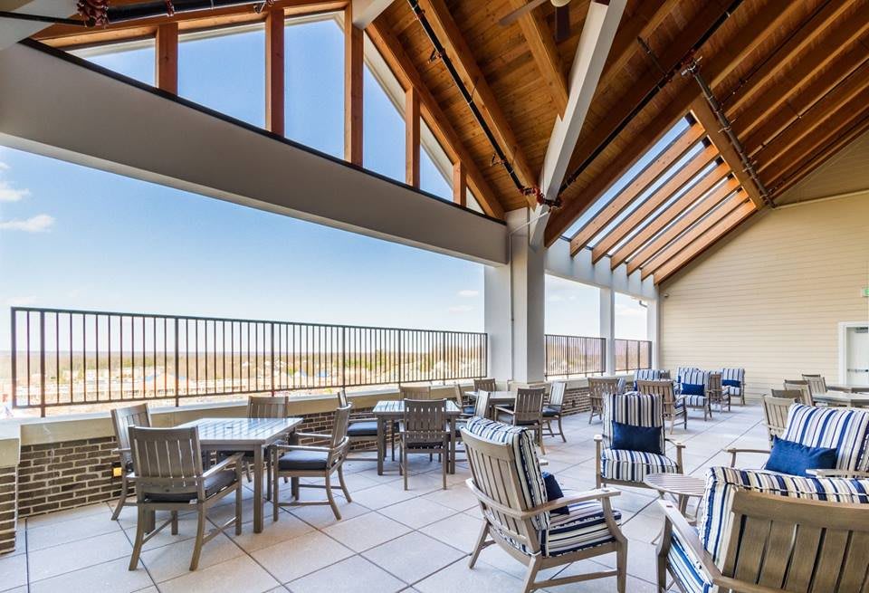 A spacious patio with modern seating, offering views through large windows.