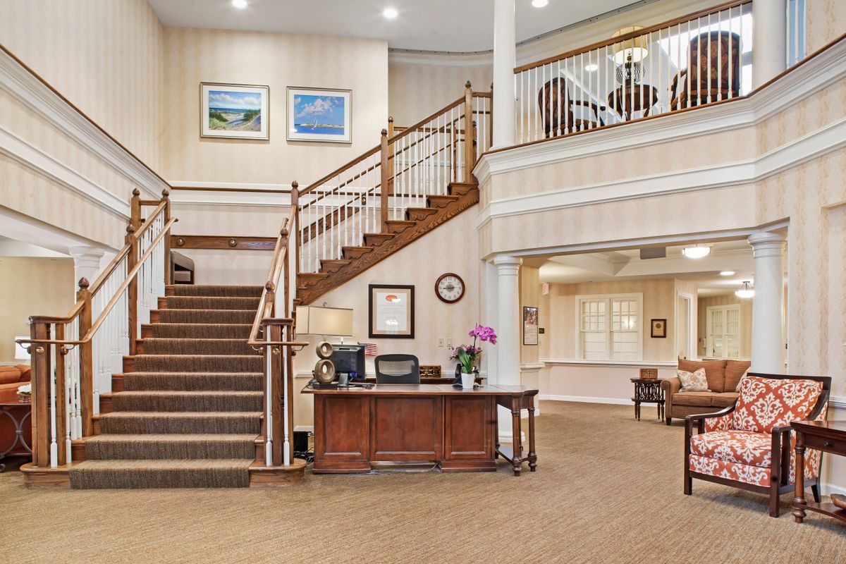 A spacious and elegantly decorated lobby with a staircase and reception desk.