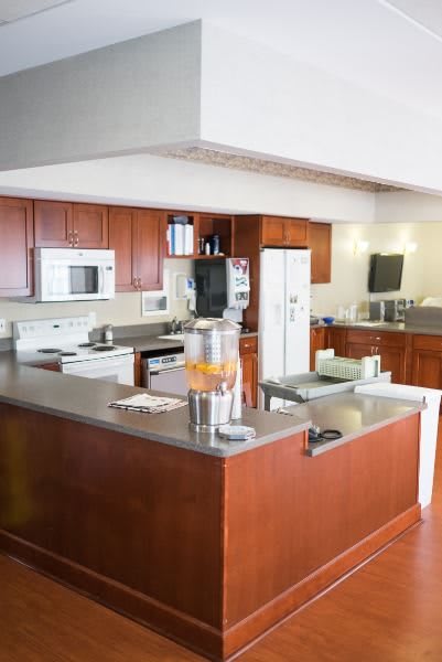 A modern kitchen with wood cabinets and various appliances.