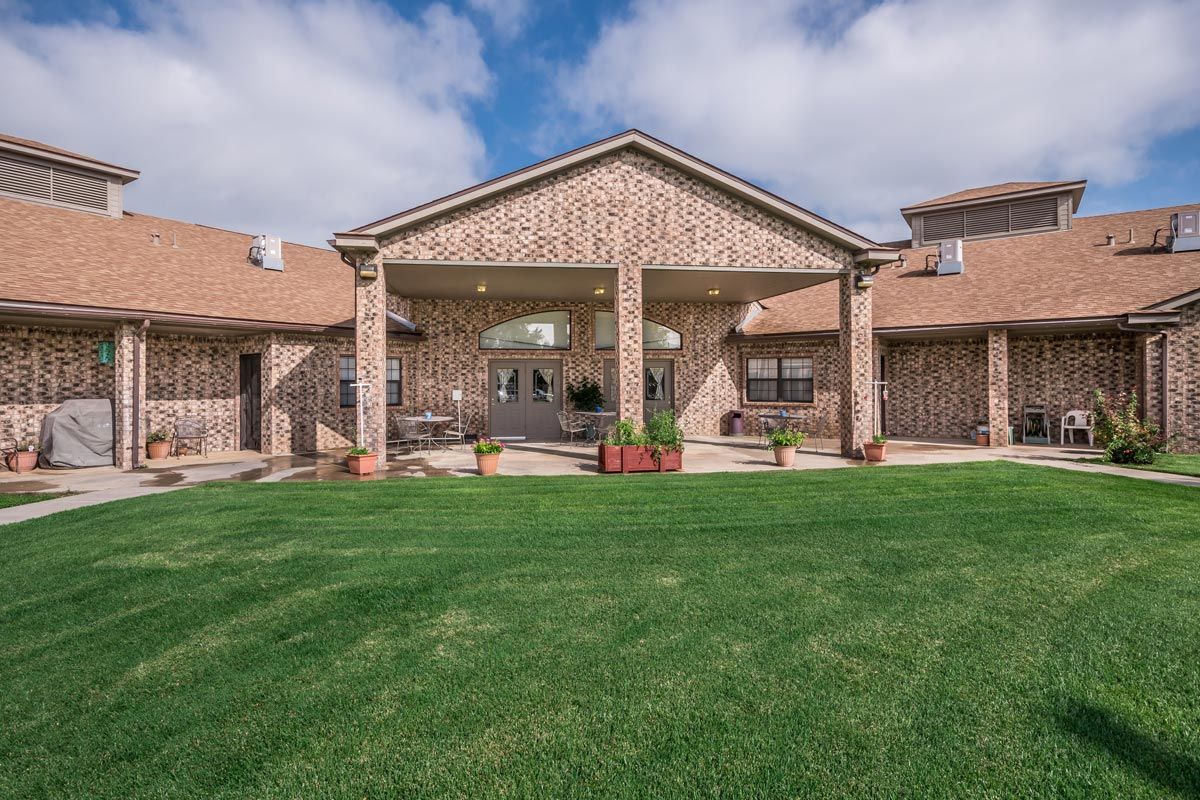 A brick building with a well-maintained lawn and clear sky.