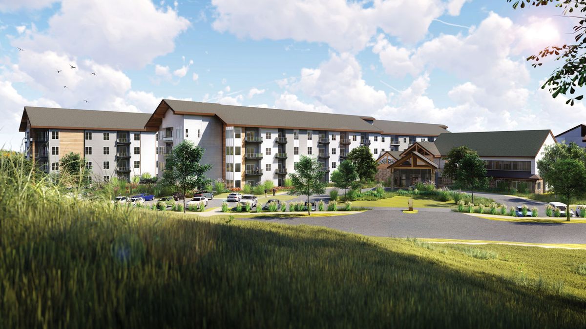 A picturesque view of a large residential building set against a scenic countryside backdrop.