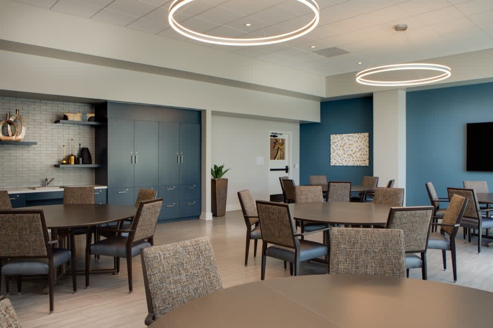 A modern interior dining area or meeting room with circular lighting fixtures and stylish furniture.