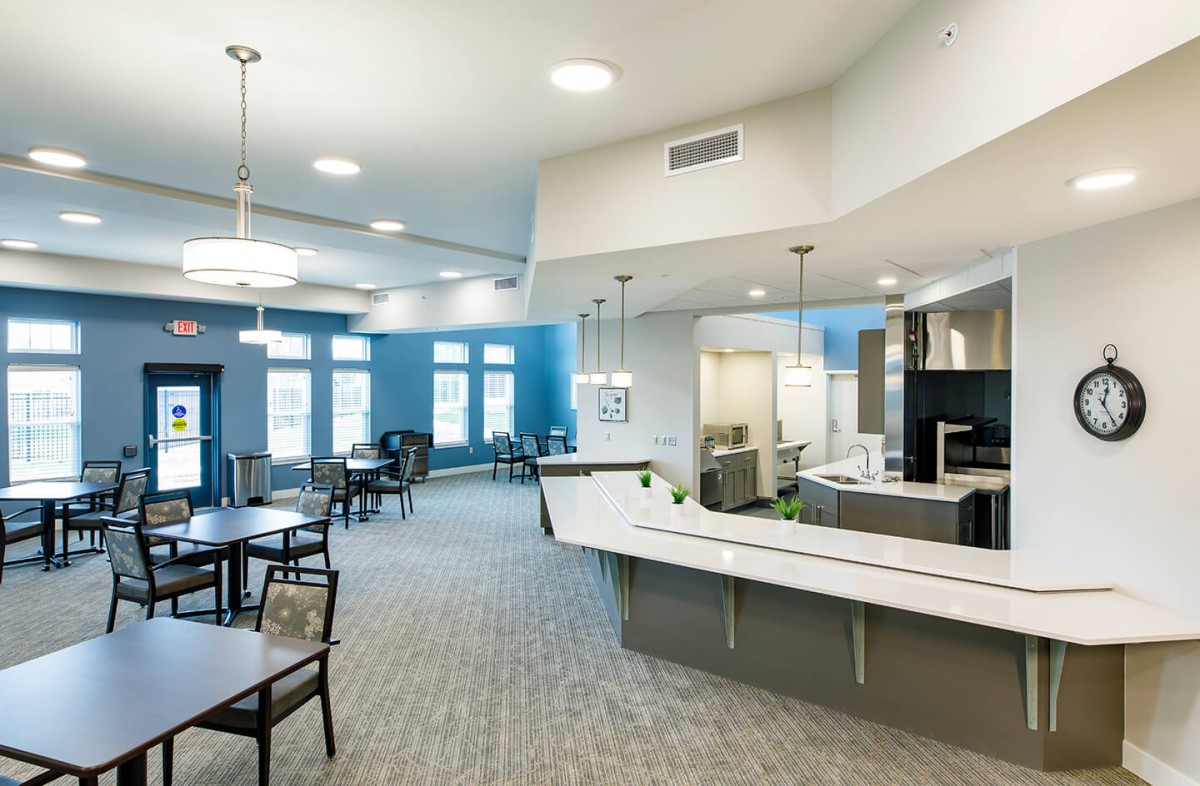 A modern lobby with a reception desk and seating area, featuring bright lighting and a minimalist design.