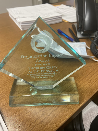 An award for organizational impact displayed on a desk.