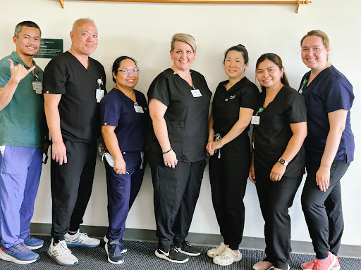A dedicated healthcare team posing together in their professional attire.