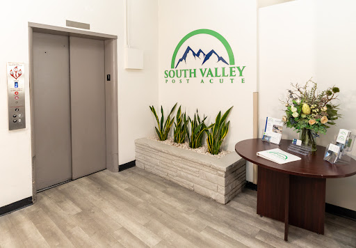 A welcoming reception area featuring an elevator, decorative plants, and a company logo.