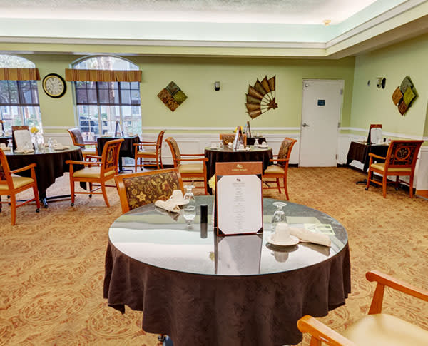 A well-arranged dining room with tables and chairs set for guests.
