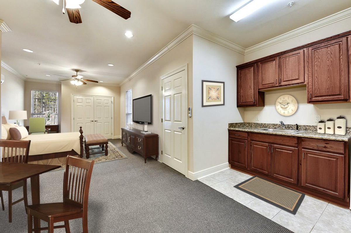 A spacious living area with a combined kitchen and dining setup, featuring warm wooden cabinetry and modern amenities.