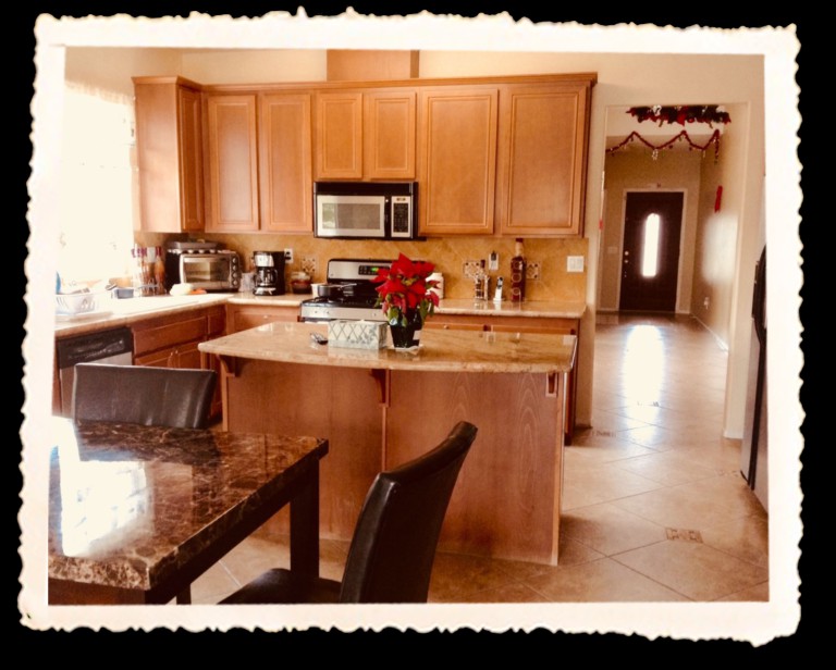 A modern kitchen with wooden cabinets, a central island, and dining area.