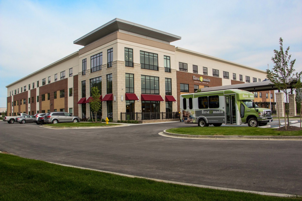 A modern commercial building with a bus parked in front.