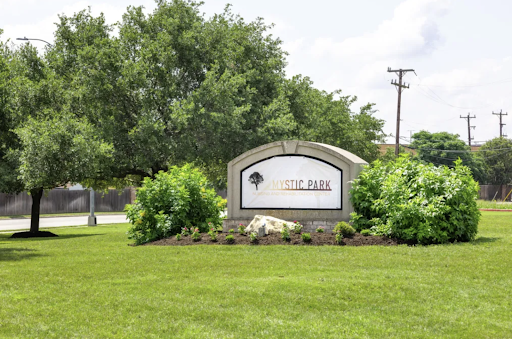 Welcome sign to a park surrounded by lush greenery.