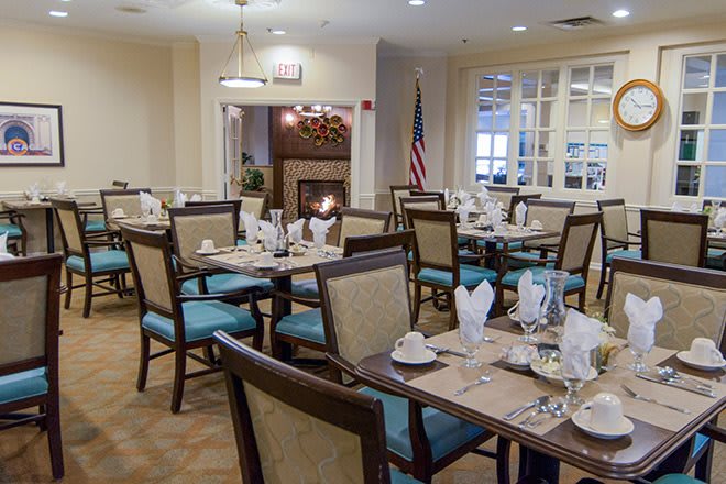 An elegantly set dining room with neatly arranged tables and chairs.