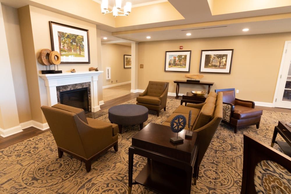 A cozy living room with comfortable seating and a fireplace, adorned with artwork on the walls.